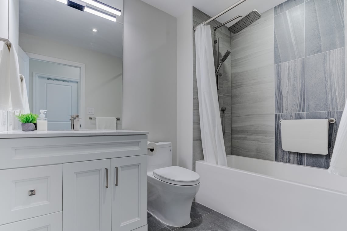 Luxury condo bathroom renovation in Toronto with tub and shower combo and large format tiling
