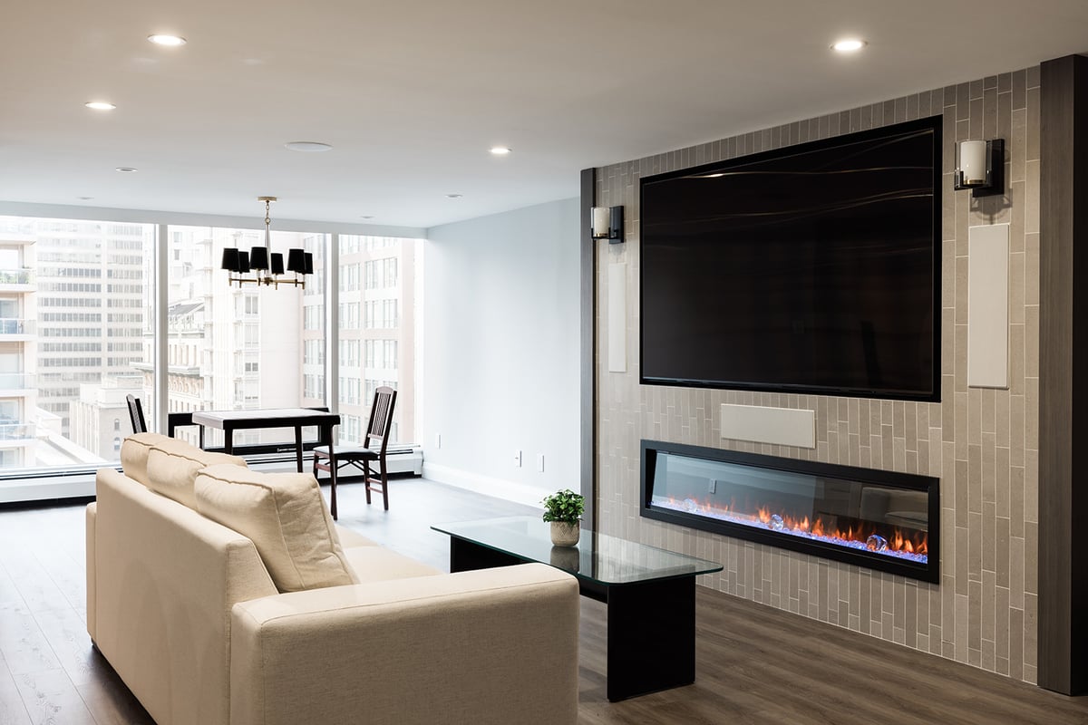 Custom fireplace in living room in downtown Toronto condo with floor-to-ceiling windows