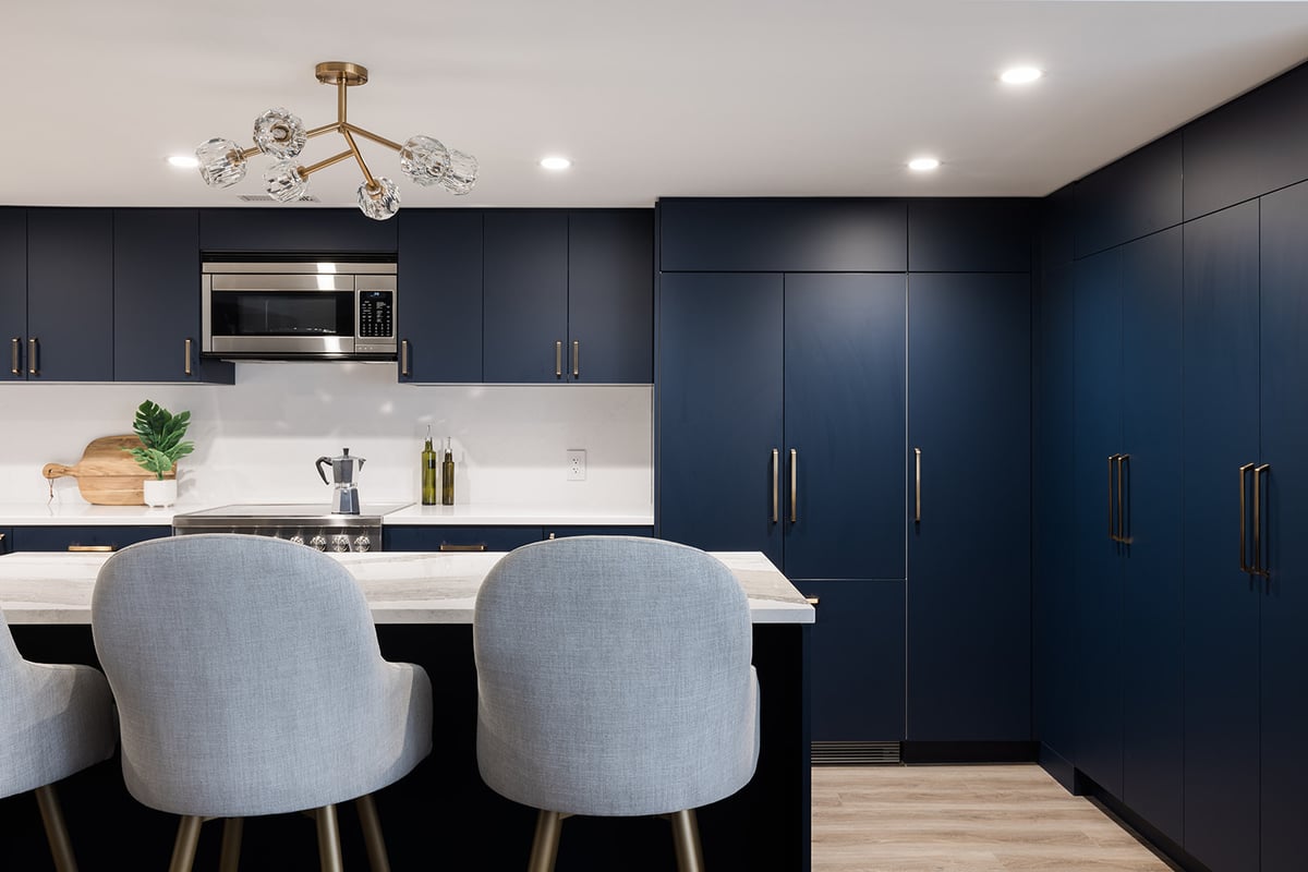 View of chairs at kitchen island and floor-to-ceiling cabinets in downtown Toronto full condo renovation