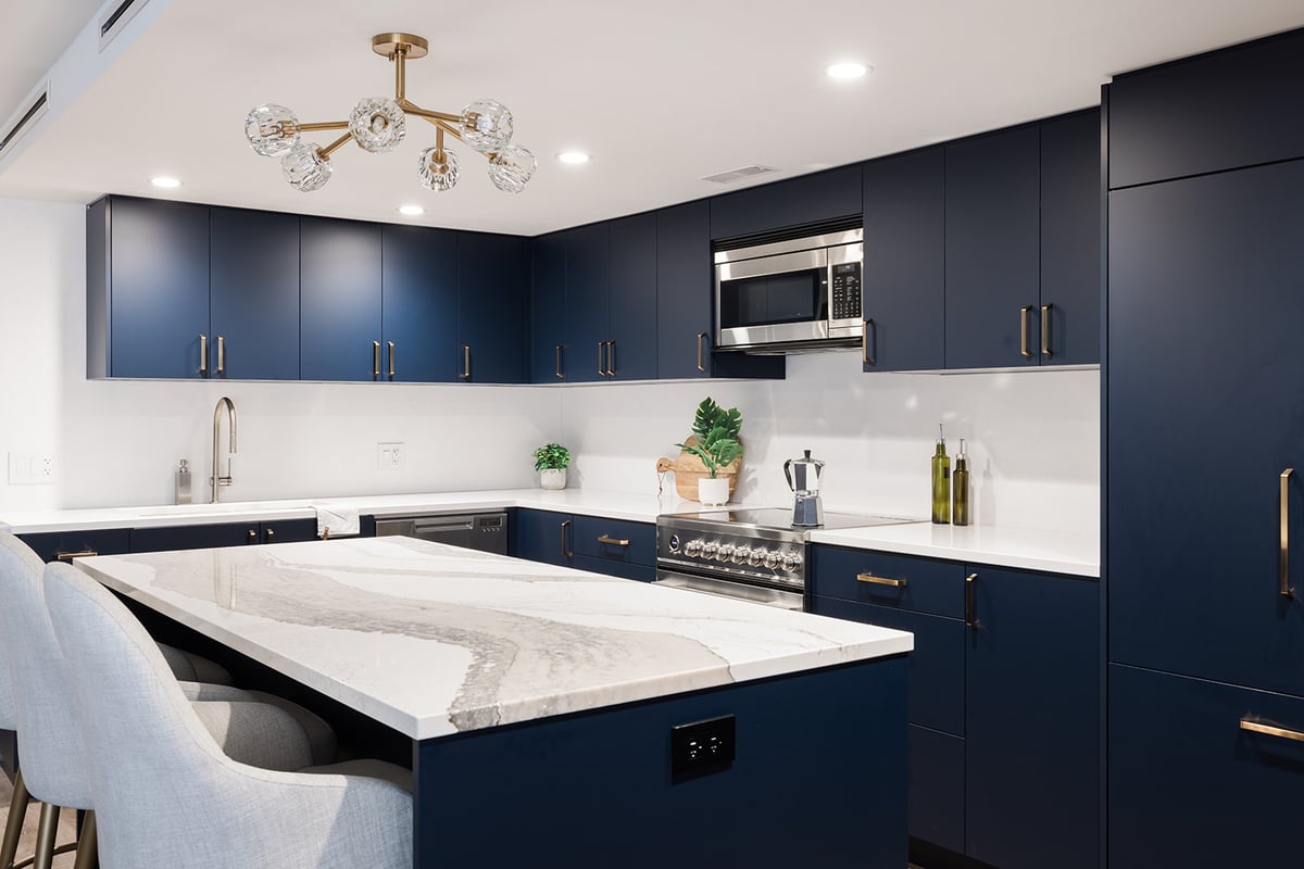 View of chairs at kitchen island in open-concept Toronto kitchen condo renovation with stone countertop