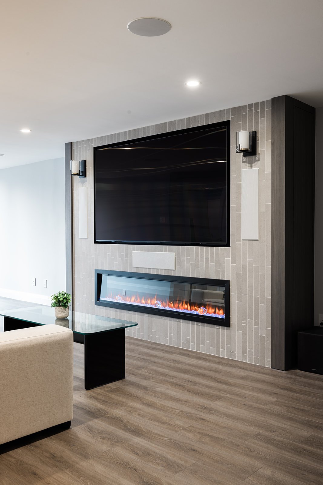 View of custom fireplace in living room in downtown Toronto condo renovation with recessed lighting above fireplace