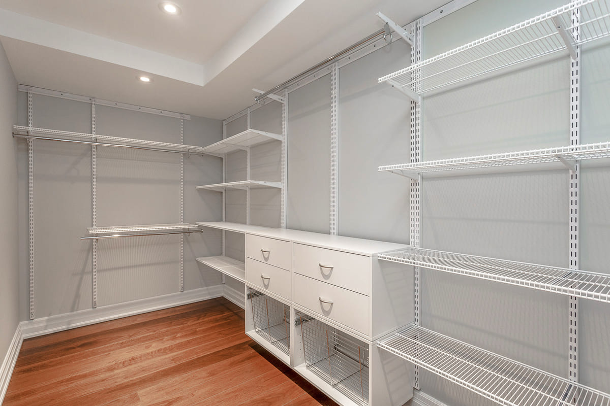 Walk-in closet with custom shelving with hard wood flooring in Toronto condo bedroom renovation by Golden Bee Condos