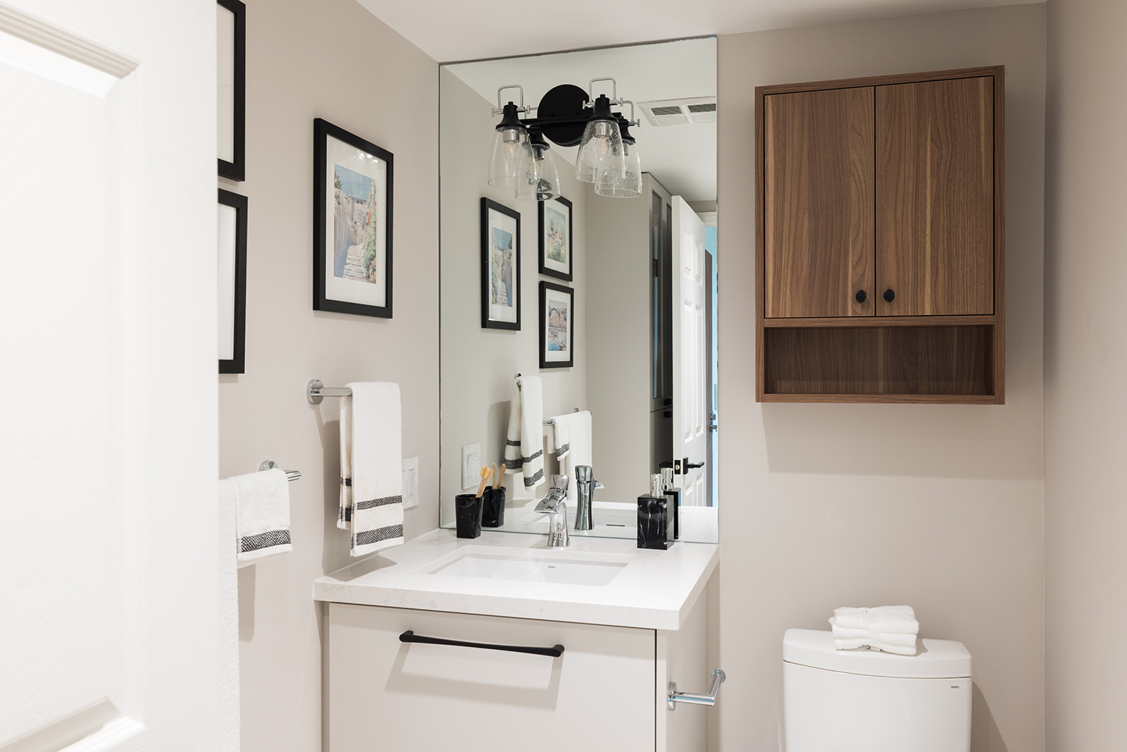 Mirror and custom wood storage above toilet in GTA condo renovation
