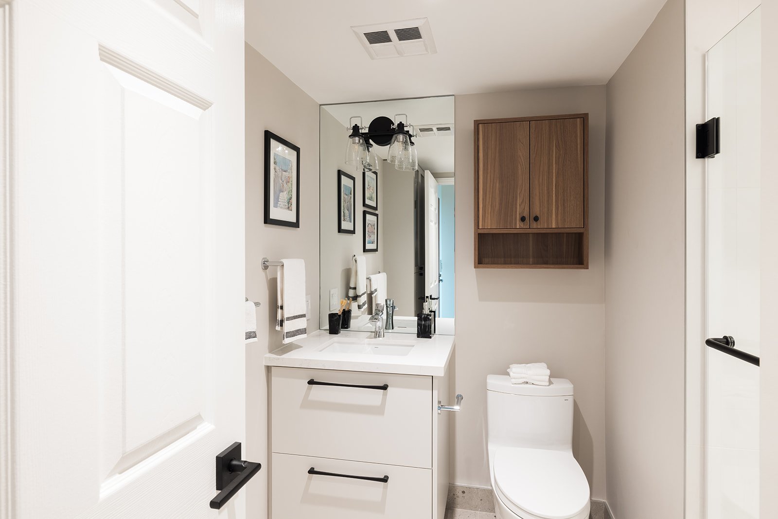 Mirror, vanity, and custom storage above toilet in GTA condo renovation