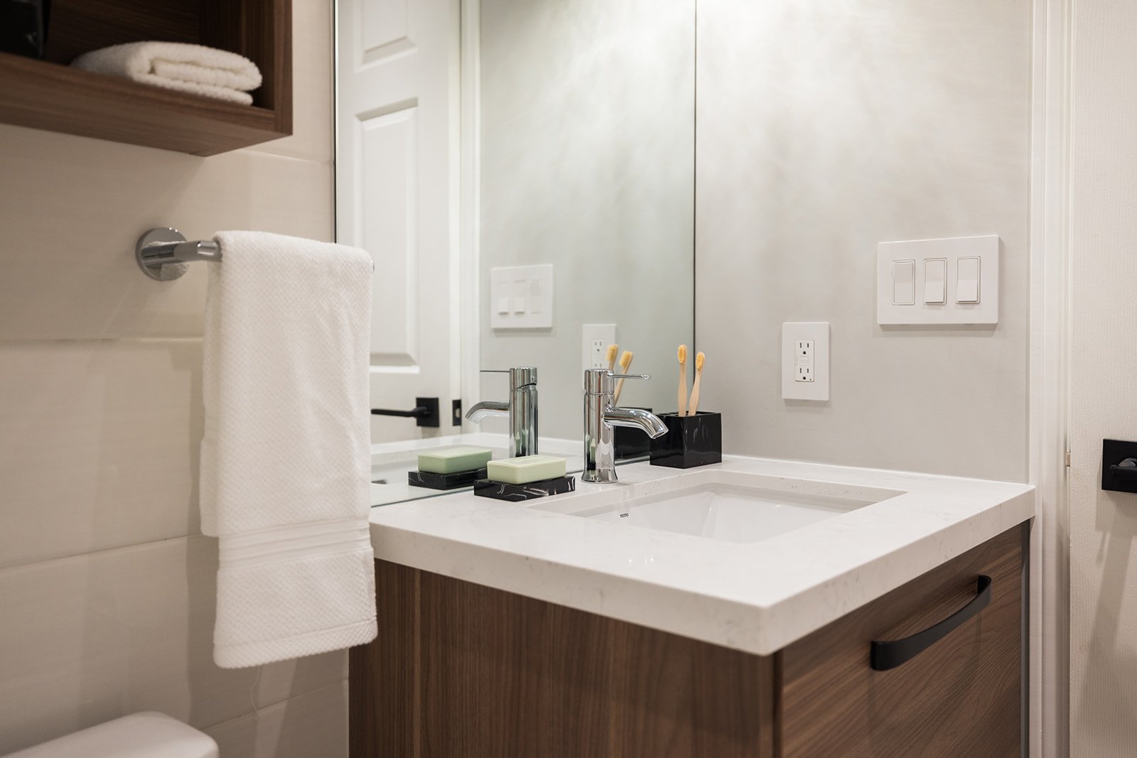 Mirror, vanity, and custom storage above toilet in GTA condo renovation