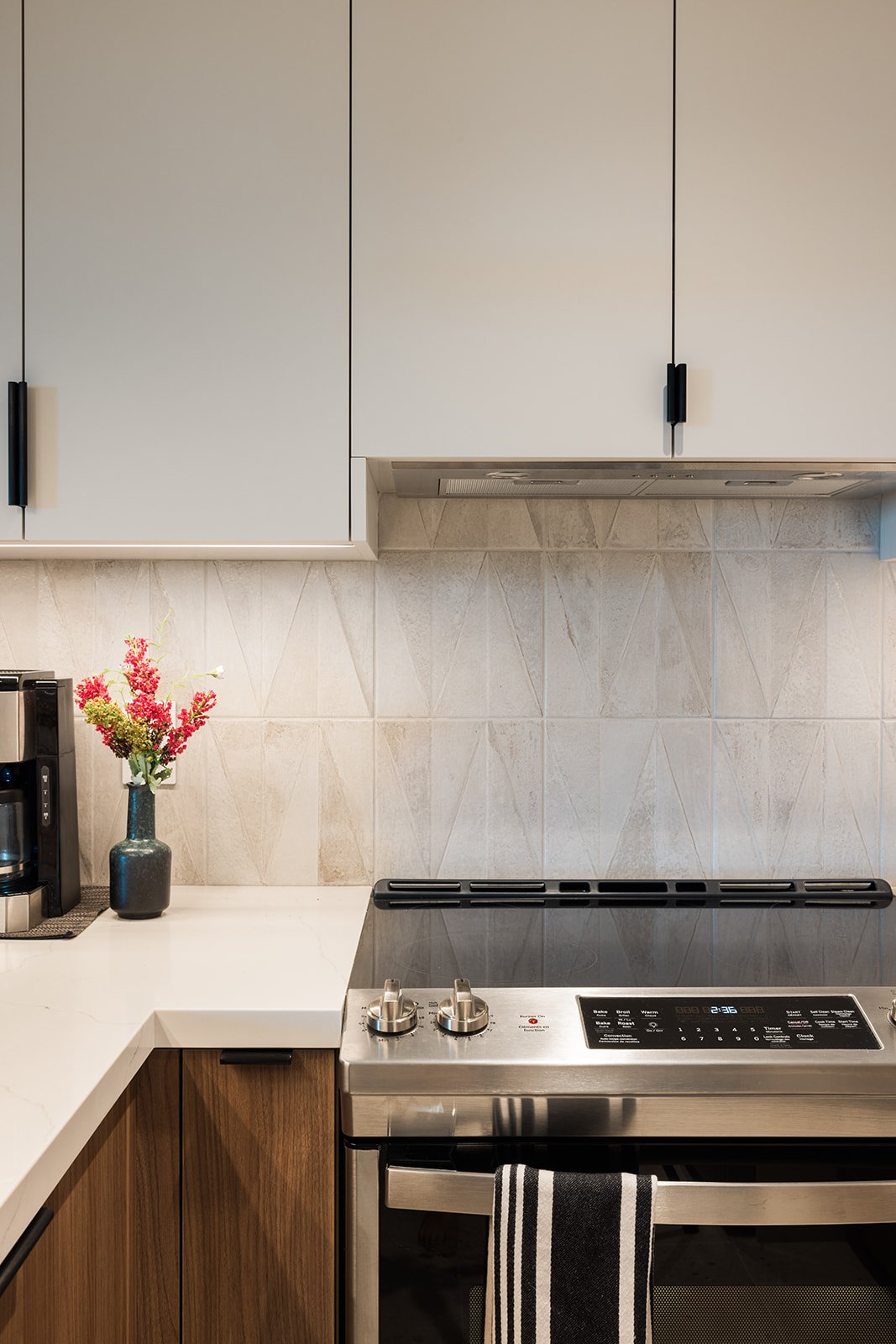Mosaic beige backsplash behind oven and cabinets in GTA condo kitchen renovation