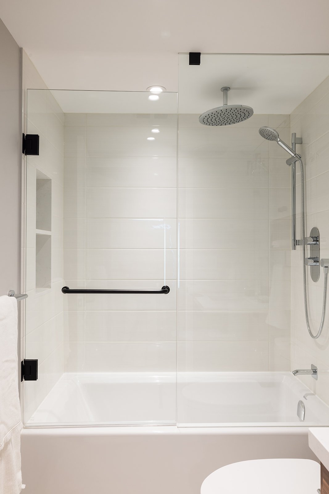 Tub shower combo in GTA condo bathroom renovation with sliding glass door