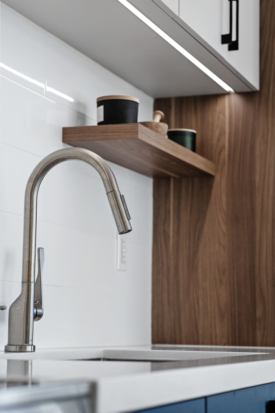 Stainless steel sink faucet in GTA condo kitchen renovation with task lighting and built-in shelving