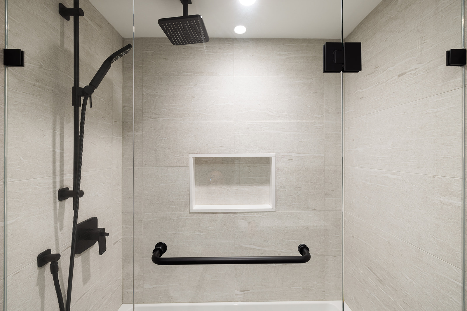 Custom tub and shower combo with built-in shelving and faucet head