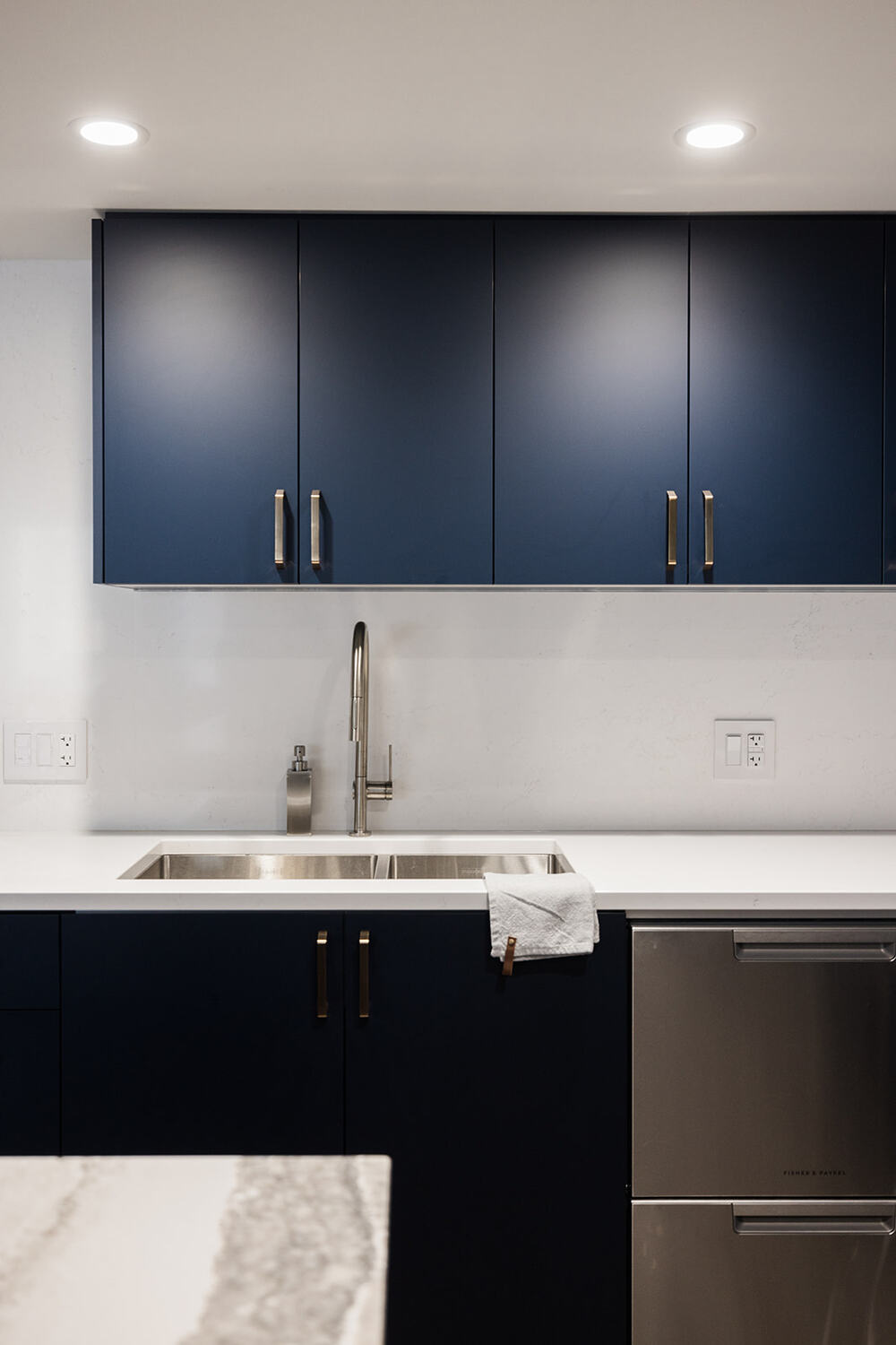 Custom under mount sink in luxury condo kitchen renovation in downtown Toronto by Golden Bee Condos with blue cabinets