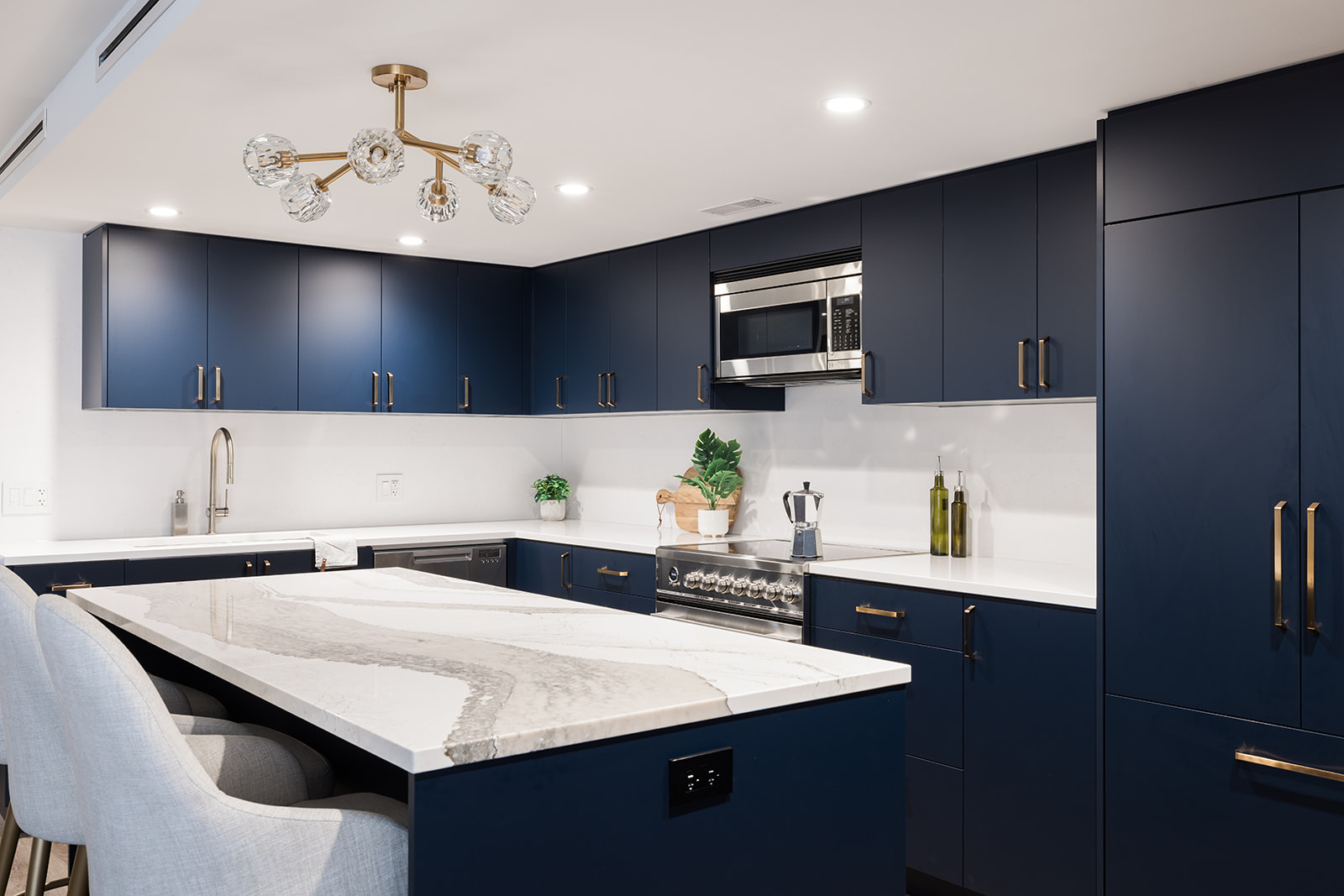 View of luxury condo kitchen renovation in downtown Toronto with dark blue flat panel cabinets by Golden Bee Condos