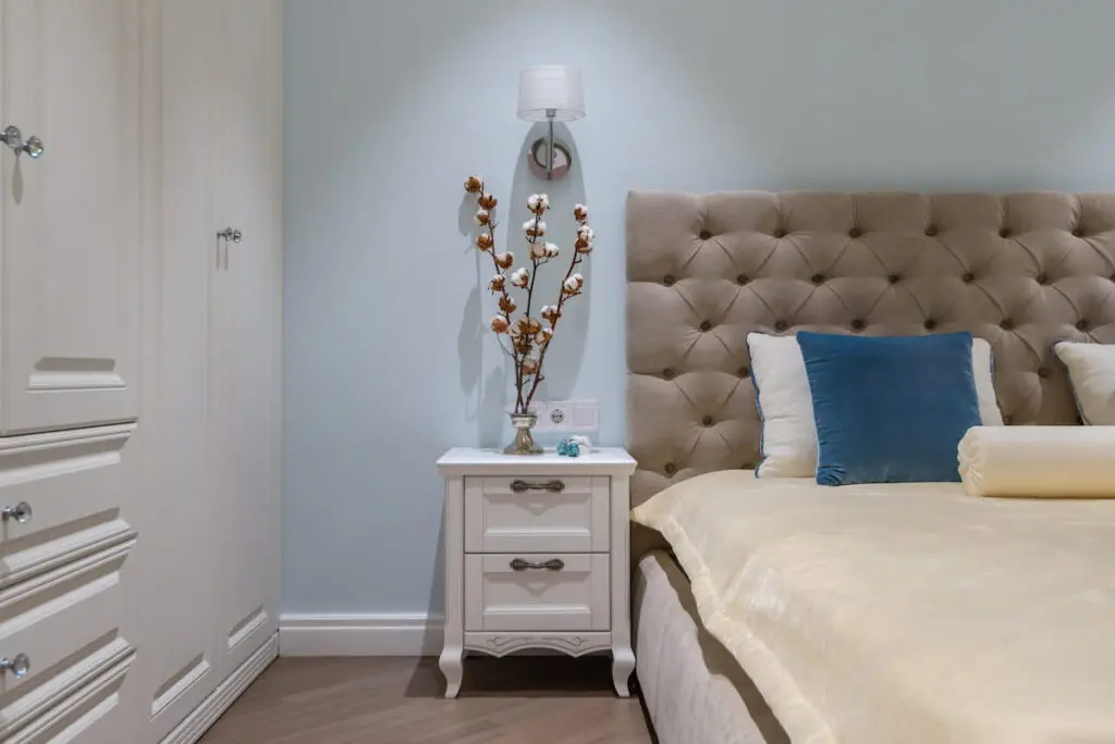 Side table and mounted lighting sconce next to bedroom in Toronto condo renovation