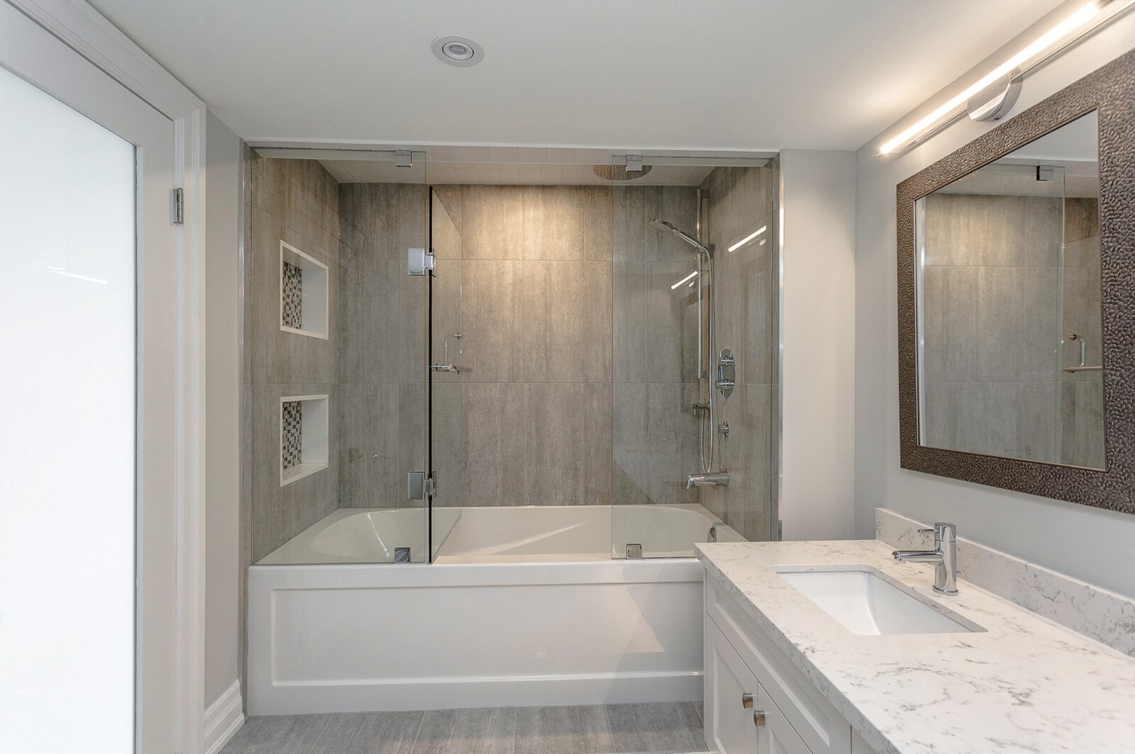 spa sized tub with shower niches in bathroom renovation condo in Toronto